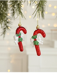 Detail of red candy cane ornament with white bow on Christmas tree branch