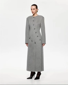 Détail d'un manteau en laine gris avec fermeture à boutons diagonale asymétrique et texture