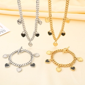 Détail de chaînes cubaines argentées et dorées avec pendentifs cœur et fermoirs en T