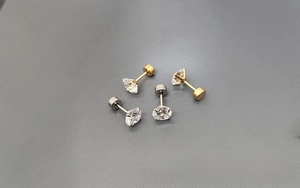 Detail of 316L stainless steel stud earrings set with crystal zircons in gold and silver