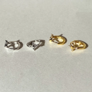 Makroaufnahme von S925 Silber- und Gold-Creolen mit Kreuz und Zirkonia-Kristallen