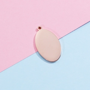 Close-up of a rose gold oval mirror-finish stainless steel tag for DIY jewelry making