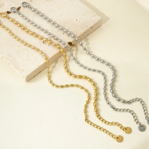Detail of beaded oval chain bracelets in gold and silver steel with lobster clasp