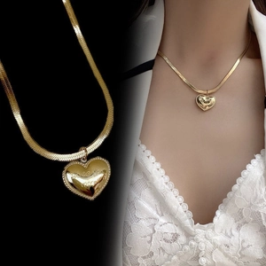 Detail of gold snake chain with heart pendant engraved with Love You More quote