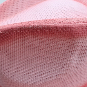Macro view of pink woven texture and fine craftsmanship on a summer cowboy straw hat