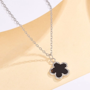 Dettaglio macro della collana in argento 925 con elegante ciondolo a fiore di trifoglio nero