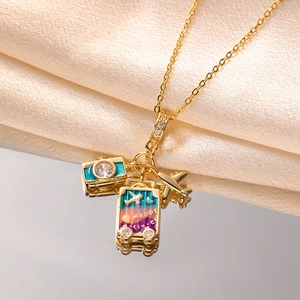 Golden travel pendant necklace with camera, happy suitcase and airplane charms