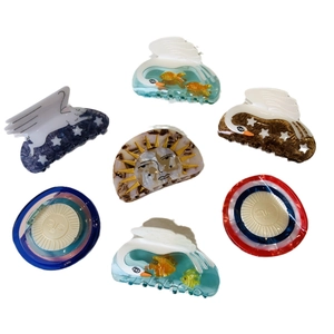 French vintage style acetate hair claw set featuring sun star and swan designs on white