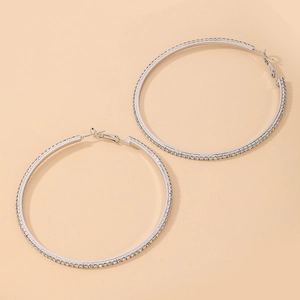 Close-up of silver-plated hoop earrings with sparkling rhinestones and a metal finish