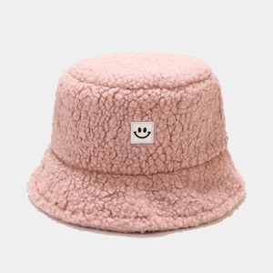 Detailed macro view of pink fuzzy teddy fleece fabric and stitched smiley face patch