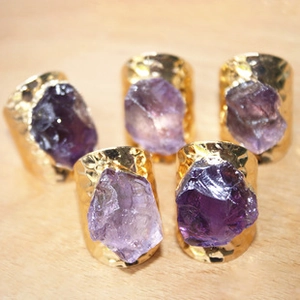 Detalle macro de piedras de amatista natural en anillos dorados vintage árbol de la vida