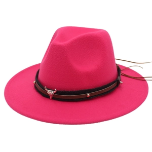Close-up of pink fedora with a black braided band featuring a silver bull skull emblem