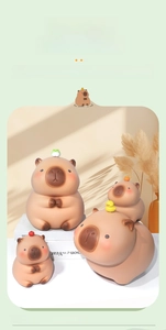 Λεπτομερής όψη τεσσάρων κουμπαράδων Capybara με αξεσουάρ μικρό βάτραχο και πορτοκάλι