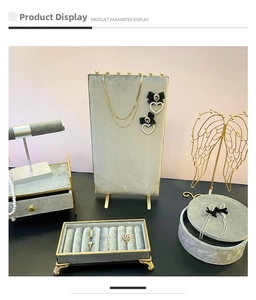 Detailed view of gray velvet jewelry display set with gold metal frames and ring trays