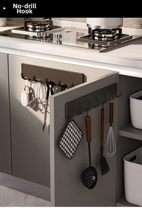 Modern wall-mounted self-adhesive hook rack holding kitchen tools and scissors