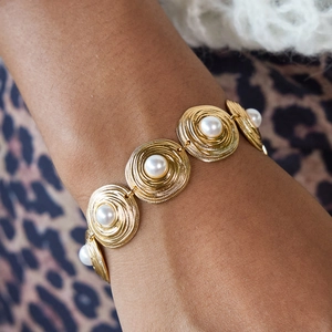Elegant 18K gold plated stainless steel bracelet with glossy pearls on woman's wrist