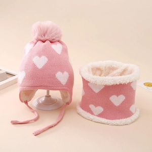 Detail von rosa Strickmütze und Schal Set mit Herzmuster und warmem Fleece-Futter