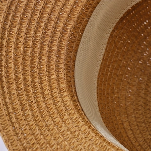 Vista macro della trama in paglia intrecciata e della fascia interna del cappello beige