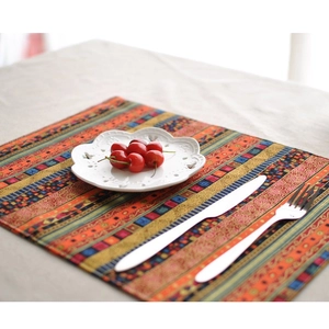 Detail of bohemian cotton linen placemat with geometric patterns and fringe edges