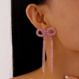 Gros plan de boucles d'oreilles nœud en cristal rose avec de longues franges