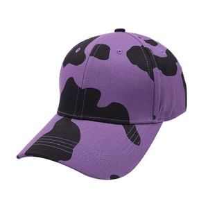 Detailed view of purple cow print baseball cap featuring reinforced stitching on curved brim