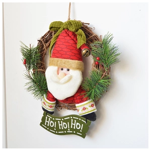 Detail of Christmas wreath with plush Santa Claus, green pine needles, and berries on vine