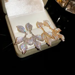 Exquisite gold and silver leaf earrings with sparkling zircon inlay in a gift box