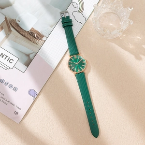 Close-up of emerald green watch face with diamond markers and rose gold case detail