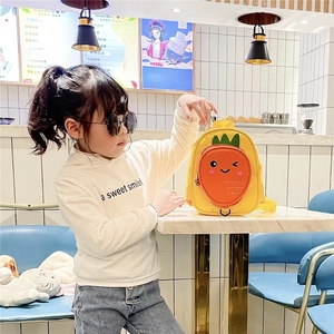 Cute yellow canvas backpack with carrot face design for toddlers shown in bright cafe