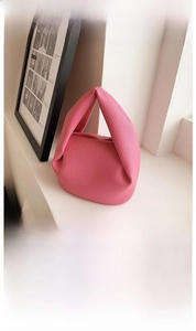 Detailed view of pink lychee texture leather on a pleated knot cloud handbag