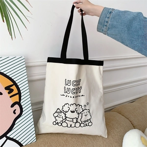 Detail of canvas tote bag featuring lucky lucky text and cute cartoon dog illustrations