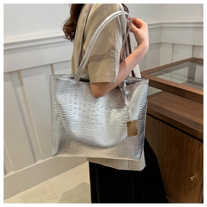 Silver crocodile pattern tote bag shown over-the-shoulder to display size and fit