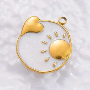Macro detail of a 18K gold heart tarot pendant with sun motif and white enamel finish