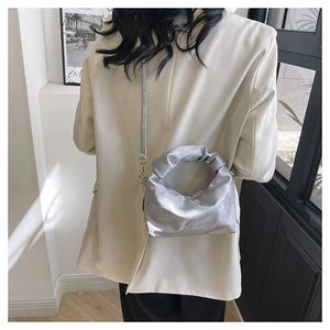 Silver pleated metallic shoulder bag shown from behind to display size and fit