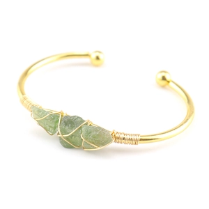 Handmade gold wire wrapped cuff bracelet with three green raw crystal stones