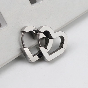Macro view of minimalist silver stainless steel heart-shaped geometric hoop earrings