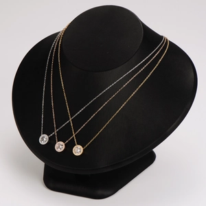 Halo pendant necklaces in silver, rose gold, and gold on black bust displays