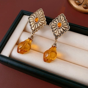 Detailed close-up of vintage gold earrings with amber resin water drop pendants