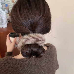 Vista dettagliata dell'elastico in finta pelliccia a righe su un'acconciatura a chignon