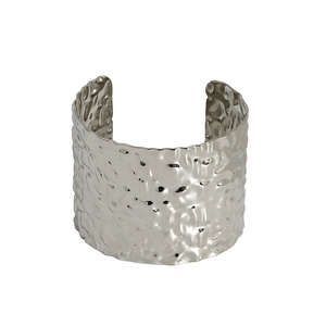 Detail of silver stainless steel cuff bracelet featuring irregular hammered metal texture