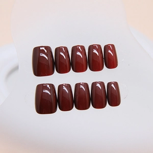 Glossy cherry red handmade press-on nails set in square shape displayed on clear board