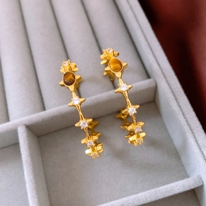 Close-up of 18k gold plated C-shape hoop earrings with brown tiger eye stone and zircons