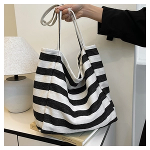 Detail shot of the large canvas tote bag featuring classic black and white stripes
