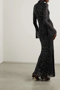 Detail of elegant black long-sleeve evening gown with silver sequins and flared cuffs