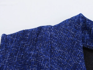 Close-up of blue tweed fabric texture on a sleeveless suit jacket with white threads