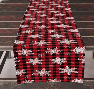 Detail of red and black checkered Christmas table runner with white snowflake patterns