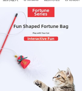 Detail of red festive cat teaser wand with lucky pouch, bell and white feathers