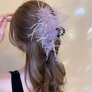 Macro detail of lavender feather hair claw clip with sparkling rhinestone tassels
