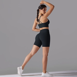 Vista posteriore del reggiseno sportivo nero con incrocio e pantaloncini fitness a vita alta