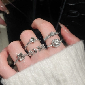 Detailed view of silver zircon ring set featuring emerald cut and halo solitaire styles